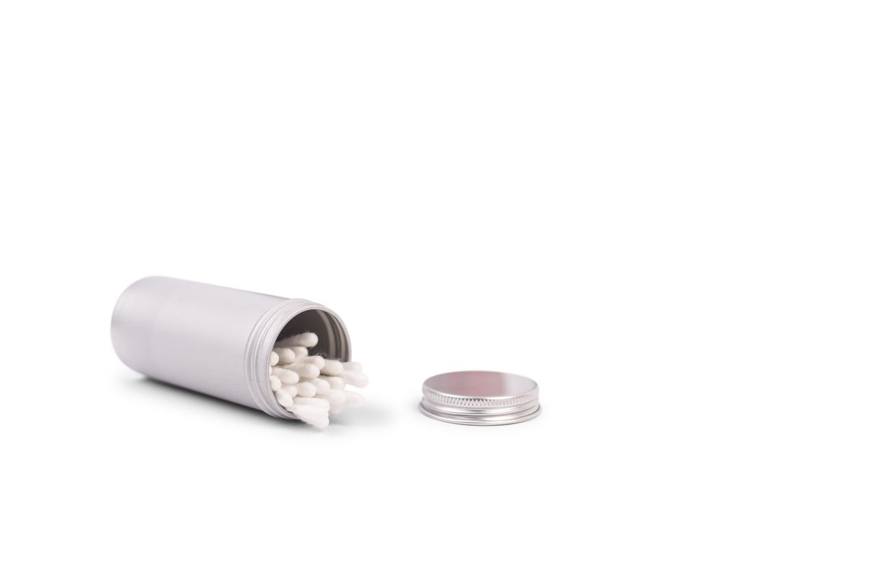 Geöffnete 135 ml Aluminiumdose, gefüllt mit Wattestäbchen, neben dem abgeschraubten Deckel.