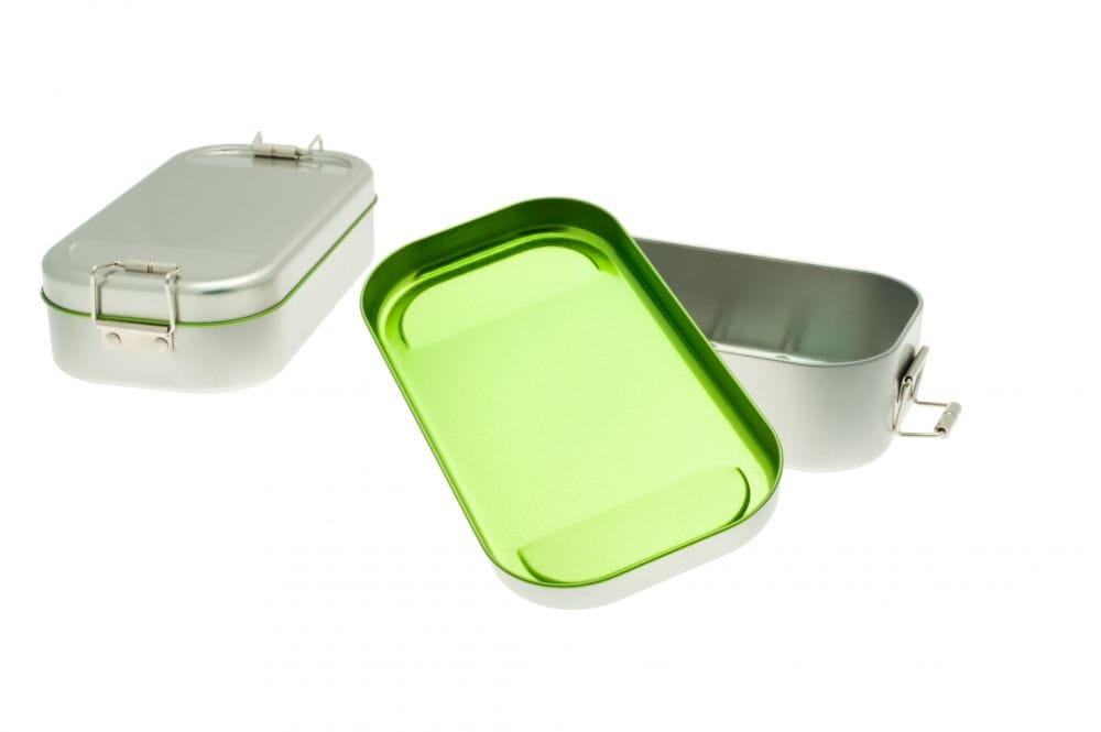 Geöffnete Lunchbox aus silberfarbenem Edelstahl mit grün gefärbter Innenseite, daneben eine zweite geschlossene Box, auf weißem Hintergrund fotografiert.