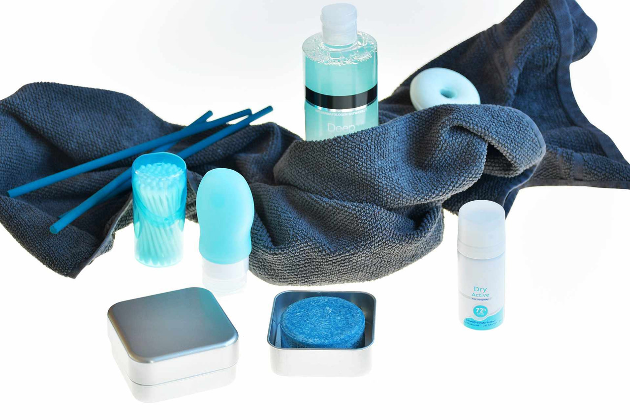 Quadratische Metalldose mit blauem Shampoo-Bar und Pflegeprodukten