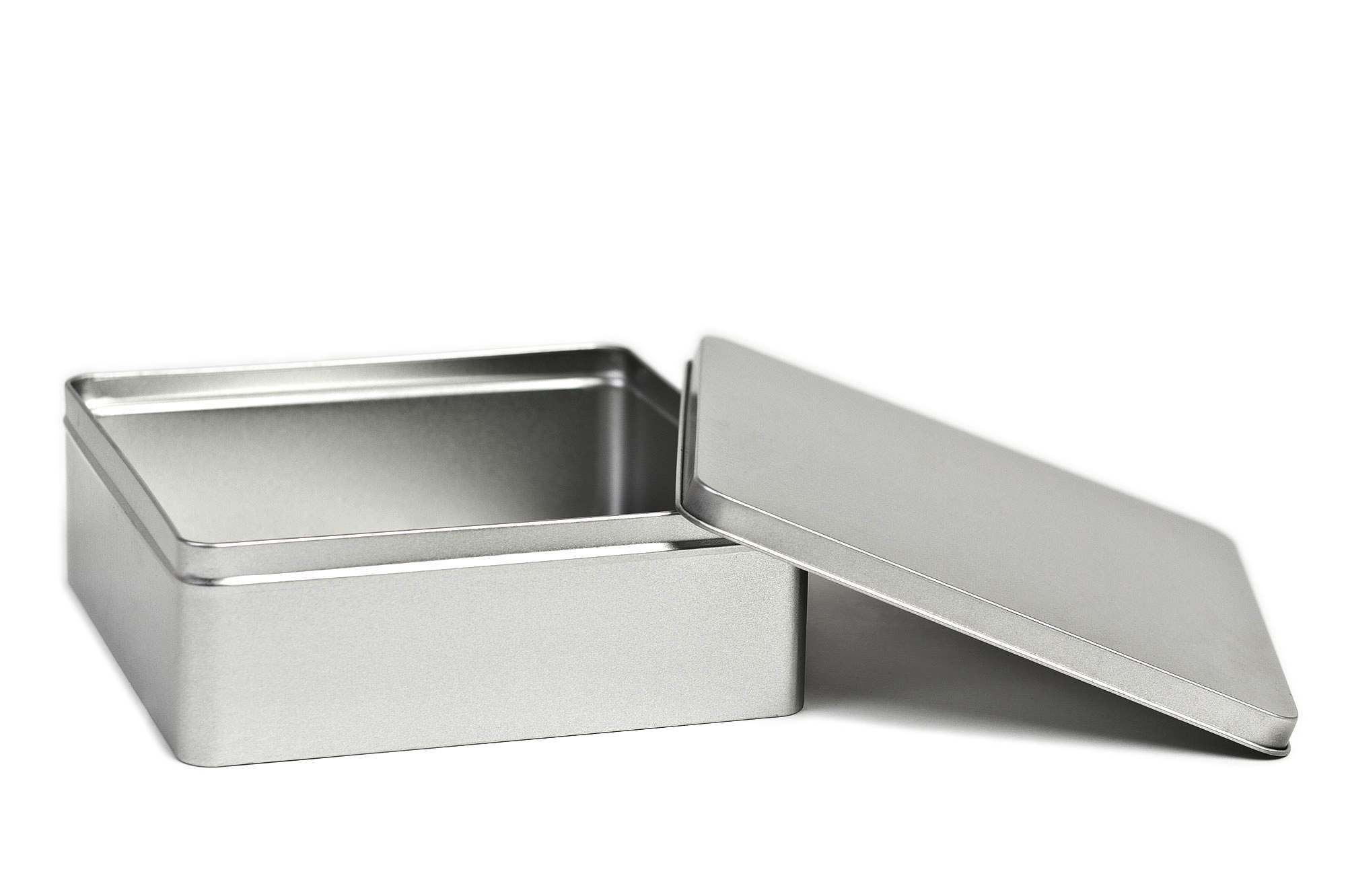 Geöffnete, quadratische Blechdose aus Weißblech mit abgenommenem Stülpdeckel neben der Dose.