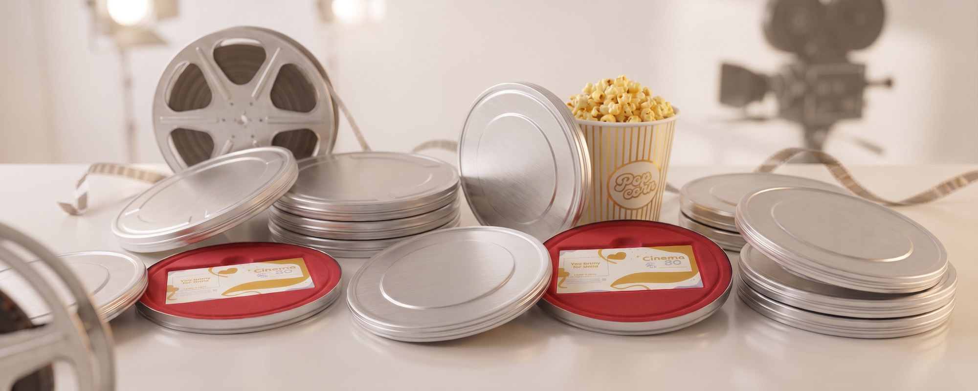 Filmdosen aus Metall mit geöffneten Deckeln, roten Innenseiten und Kinokarten, kombiniert mit Filmrollen und Popcorn im Kino-Design.
