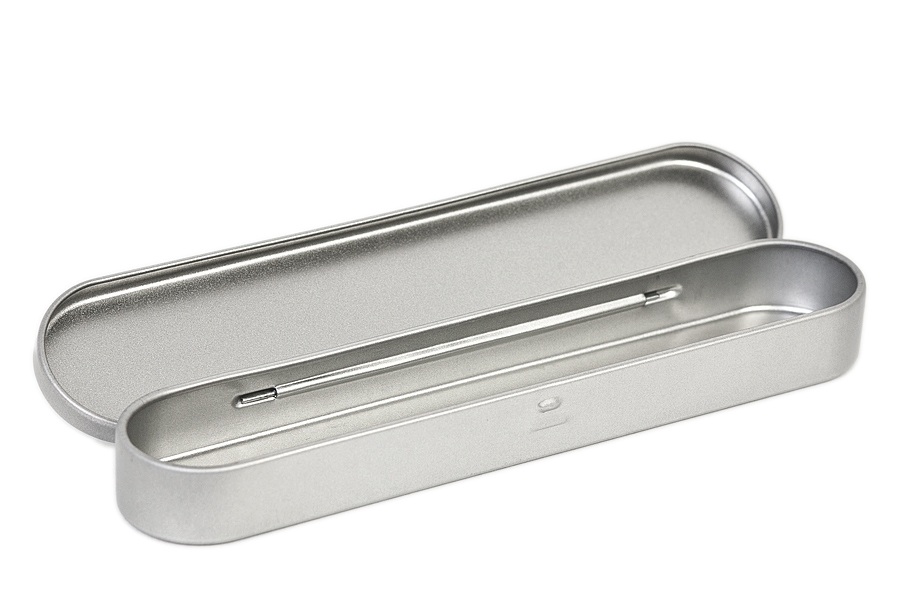 Offene silberfarbene, längliche Stiftdose aus Metall mit einem kleinen Verschlussmechanismus in der Mitte, auf neutralem Hintergrund.