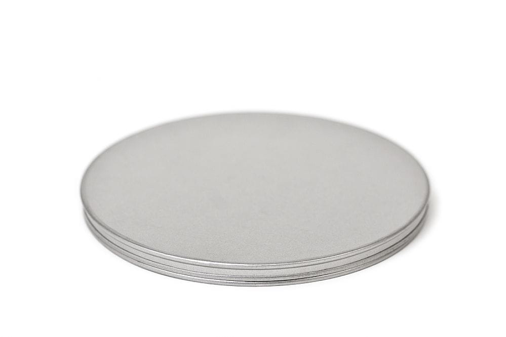 Geschlossene runde Blechdose aus silberfarbenem Metall mit Stülpdeckel, auf weißem Hintergrund fotografiert.