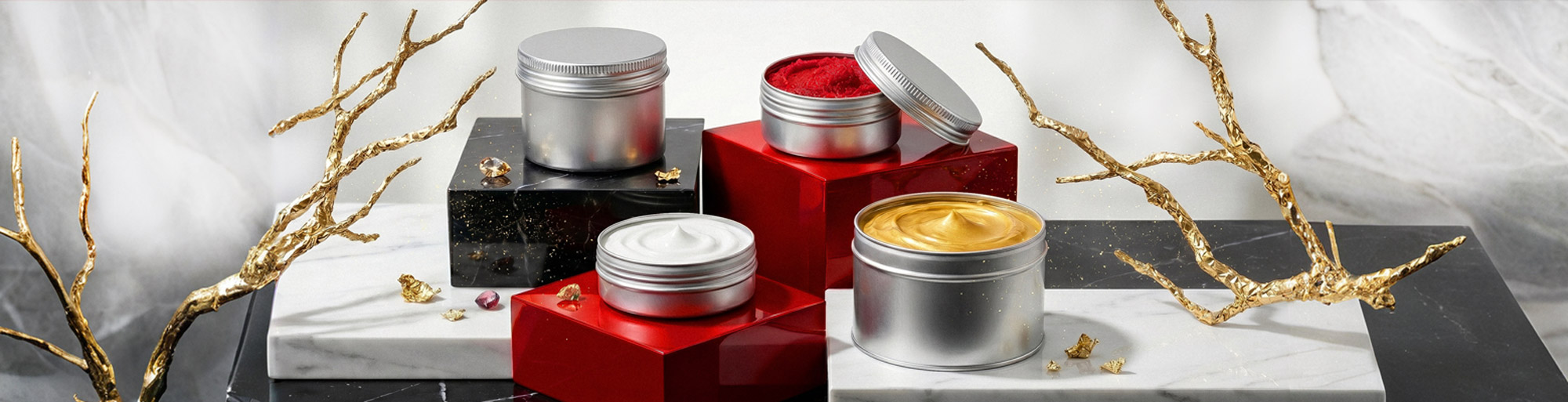 Cremedosen aus silberfarbenem Metall mit Creme, Peeling und Balsam auf Marmor- und Podestflächen; stilvolle Produktaufnahme mit goldenen Dekorationselementen.