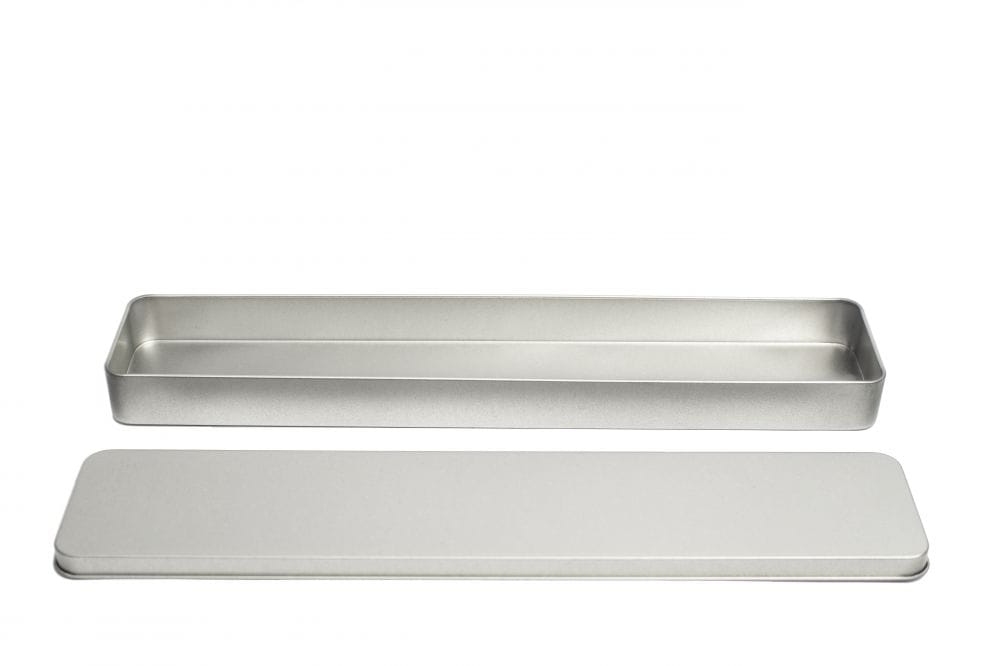 Geöffnete, längliche Blechdose aus silberfarbenem Metall mit abgenommenem Klemmdeckel, neutraler Hintergrund.
