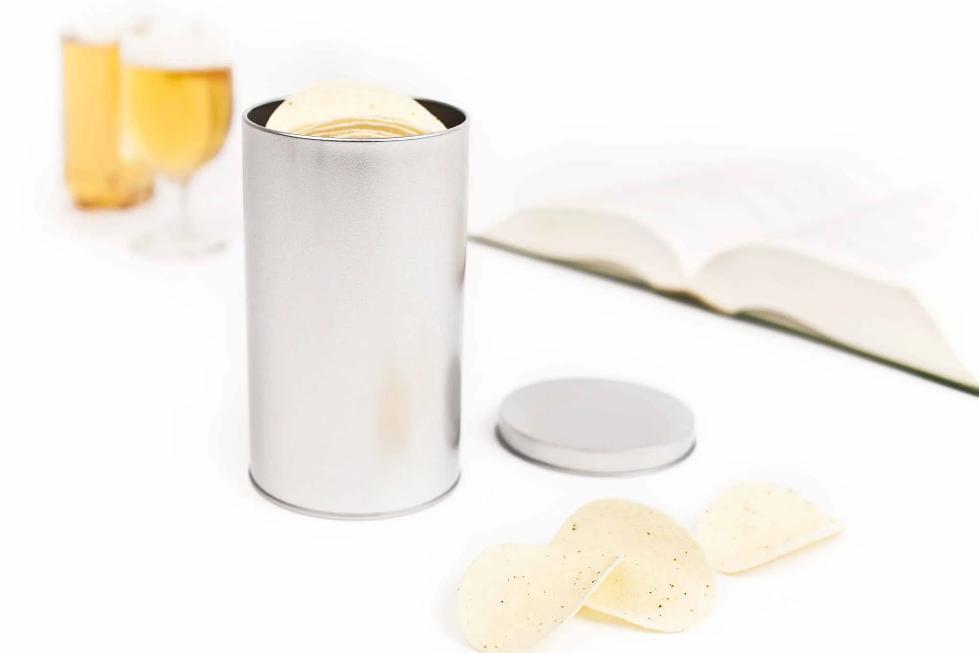 silberne Metalldose mit Deckel, geöffnet und mit mehreren kleinen Chips gefüllt