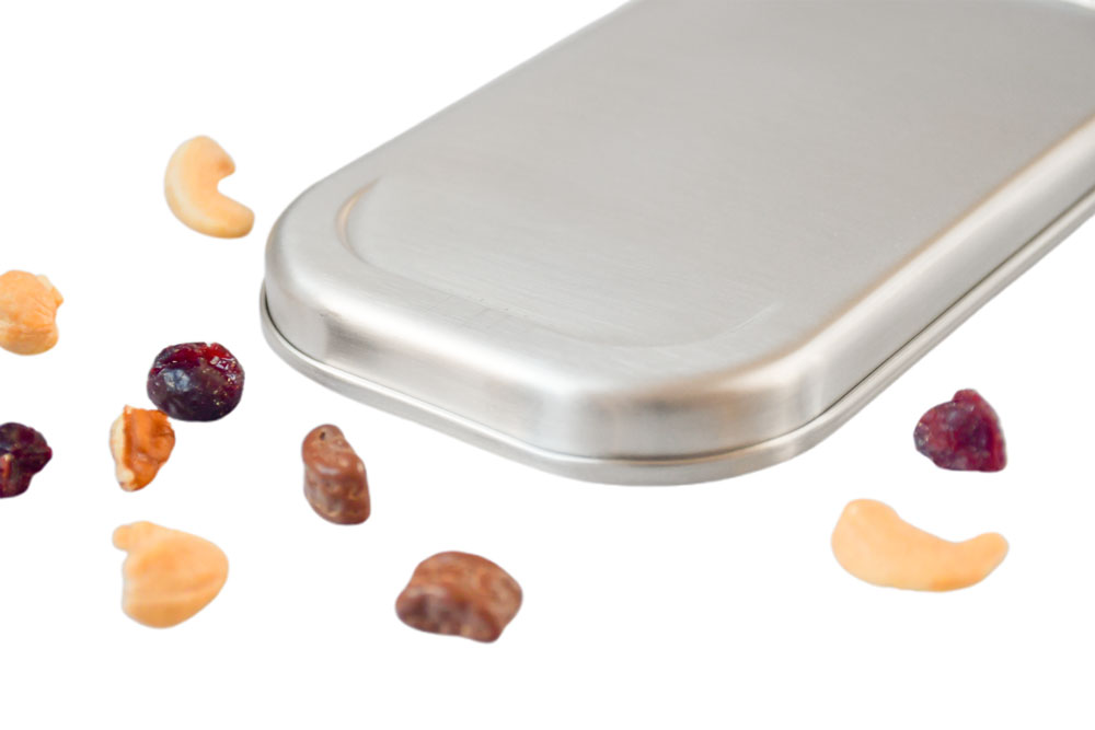 Nahaufnahme Edelstahldeckel auf weißem Hintergrund mit Cashewkernen und getrockneten Beeren – hochwertiger Ersatzdeckel für Lunchbox