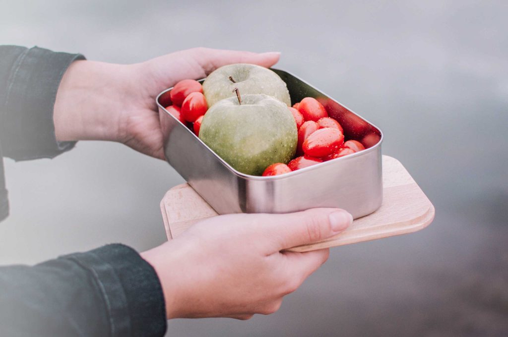 Produktbeispiel einer bedruckten Edelstahl-Lunchbox mit Buchenholzdeckel in Gebrauch